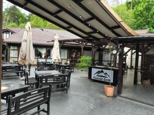 a restaurant with tables and umbrellas on a patio at Forest Grill in Piatra Neamţ