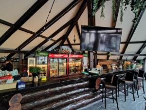 a bar with chairs and a flat screen tv at Forest Grill in Piatra Neamţ