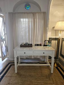 a white desk in a room with a window at Bagru Haveli in Jaipur
