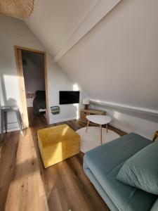 a bedroom with a bed and a living room at L'escapade ansérienne in Oye-Plage
