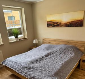a bedroom with a bed and a painting on the wall at Ferienwohnung Meeresleuchten - Glowe in Glowe