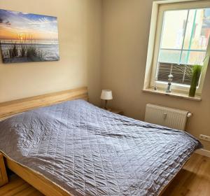 a bedroom with a bed and a window at Ferienwohnung Meeresleuchten - Glowe in Glowe