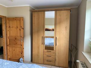 a bedroom with a wooden cabinet and a bed at Ferienwohnung Meeresleuchten - Glowe in Glowe