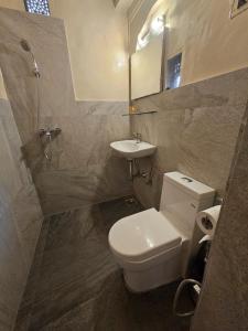 a bathroom with a white toilet and a sink at Bagru Haveli in Jaipur