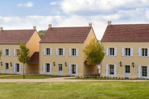 a row of houses with trees in front of them at Château Les Merles et ses Villas in Mouleydier