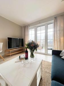 a living room with a table with a vase of flowers at Amselkoje in Süderende