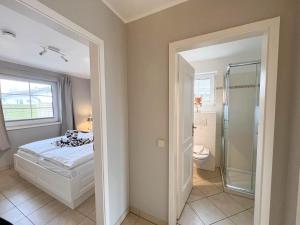 a bedroom with a bed and a glass shower at Amselkoje in Süderende +18 photos