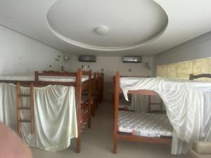 a room with three bunk beds and a ceiling at Hostel Suites in Recife