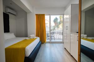 a hotel room with two beds and a balcony at Hotel Aloha in Sarandë