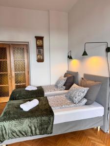 two beds in a room with a clock on the wall at Apartament Rynek 20 in Krosno