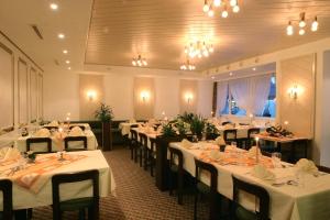 a dining room with tables and chairs with white tablecloths at Gasthaus Post in Willisau