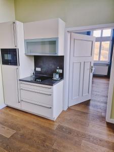 a kitchen with white cabinets and a white door at Hotel Villa Viktoria Luise in Blankenburg +22 photos