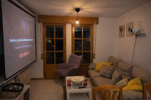 a living room with a couch and a projection screen at Treparriscos Home l Cine en casa l WIFI l Vistas in Biescas