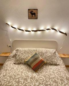 a bed with a string of lights above it at Treparriscos Home l Cine en casa l WIFI l Vistas in Biescas