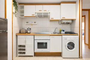 a kitchen with white cabinets and a dishwasher at Treparriscos Home l Cine en casa l WIFI l Vistas in Biescas +23 photos