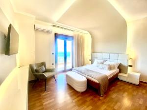 a bedroom with a bed and a chair and a window at Presidential Sea View in Mytilene