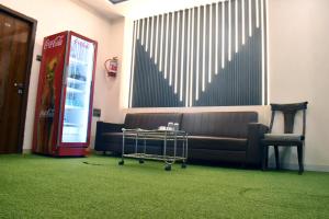a waiting room with a couch and a coke machine at Hotel Edition Blue in Mumbai