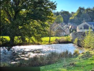 a river in a village with houses and trees at Charming 19th-Century BB in Saint-Martial-le-Mont, Creuse in Saint-Martial-le-Mont