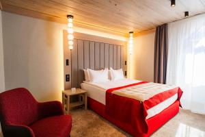 a hotel room with a bed and a chair at Alpin Resort Hotel in Poiana Brasov