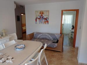 a living room with a table and a couch at Delfines Solo Familias Serviplaya in Playa de Xeraco