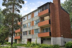 an apartment building with a brick chimney and trees at 1-Bedroom Apartment with Sauna in Heinola
