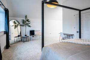 a bedroom with a bed and a table and chairs at No 4 The Halesworth in Halesworth