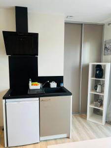 a kitchen with a white and black counter top at La Perla in Mont-de-Marsan