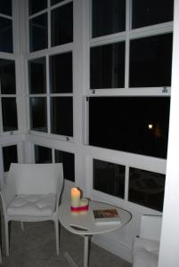 a room with large windows with a candle on a table at Pensión Acibeche in Santiago de Compostela