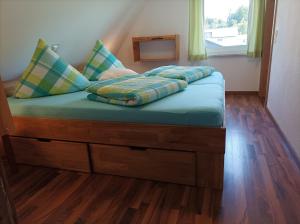 a bed with pillows on it in a room at Ferienhaus Rudolf in Achberg
