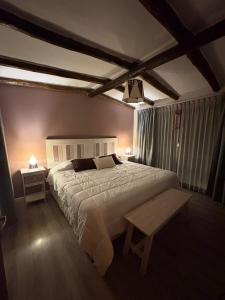 a bedroom with a large bed and two tables at Moller masi inti wayra in Purmamarca