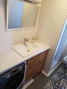 a bathroom with a sink and a mirror at Alo Alo Apartman 5 in Kruševac +7 photos