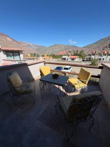 a patio with chairs and a table on a roof at Moller masi inti wayra in Purmamarca
