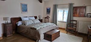 a bedroom with a bed and a table and a chair at L'Oustal des Rameaux in Brissac