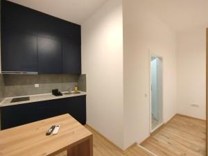 a kitchen with black and white cabinets and a wooden table at 369 Apartments in Belgrade