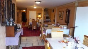 a restaurant with tables and chairs and a staircase at Bed and Breakfast Dannevirke in Owschlag