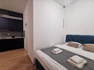 a bedroom with a large bed with towels on it at 369 Apartments in Belgrade