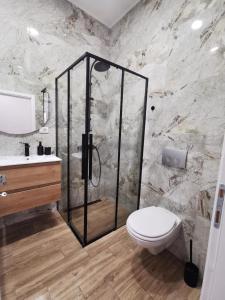 a bathroom with a shower and a toilet and a sink at 369 Apartments in Belgrade