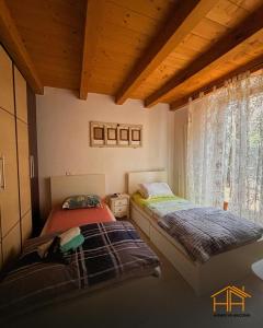 two beds in a room with a window at La casa di Agnese by Homes in Ancona in Ancona