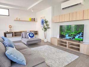 a living room with a couch and a flat screen tv at AURA STAY-Luxury Private Pool Villa walk to Kad Farang in Chiang Mai