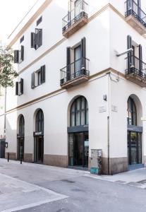 a white building with windows and balconies on a street at Hotel La Casa Del Sol in Barcelona