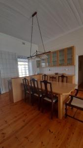 a dining room with a wooden table and chairs at House with Those Stairs in Langebaan