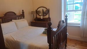 a bedroom with a large wooden bed with a mirror at House with Those Stairs in Langebaan