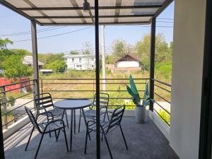 a patio with a table and chairs on a balcony at AURA STAY-Luxury Private Pool Villa walk to Kad Farang in Chiang Mai