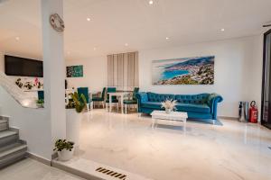a living room with a blue couch and a table at Hotel Aloha in Sarandë