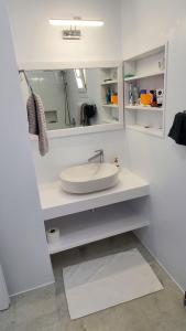 a white bathroom with a sink and a mirror at Villa E - Kamari Village in Kastraki +27 photos