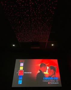 a television screen with a picture of a couple at Hollywood Spa Jacuzzi - Cinéma in Château-Thierry