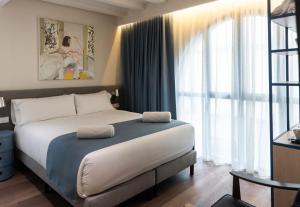 a bedroom with a bed and a large window at Hotel La Casa Del Sol in Barcelona