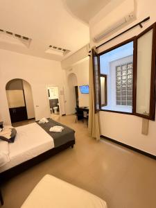 a bedroom with two beds and a large window at Hotel Plebiscito Aparthotel in Naples +151 photos