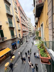 a group of people walking down a city street at Hotel Plebiscito Aparthotel in Naples