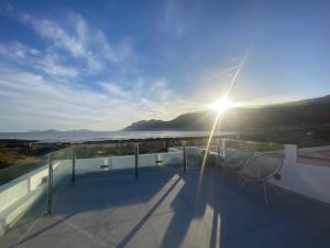 a balcony with two chairs and the sun shining at Famara ocean view house in Famara